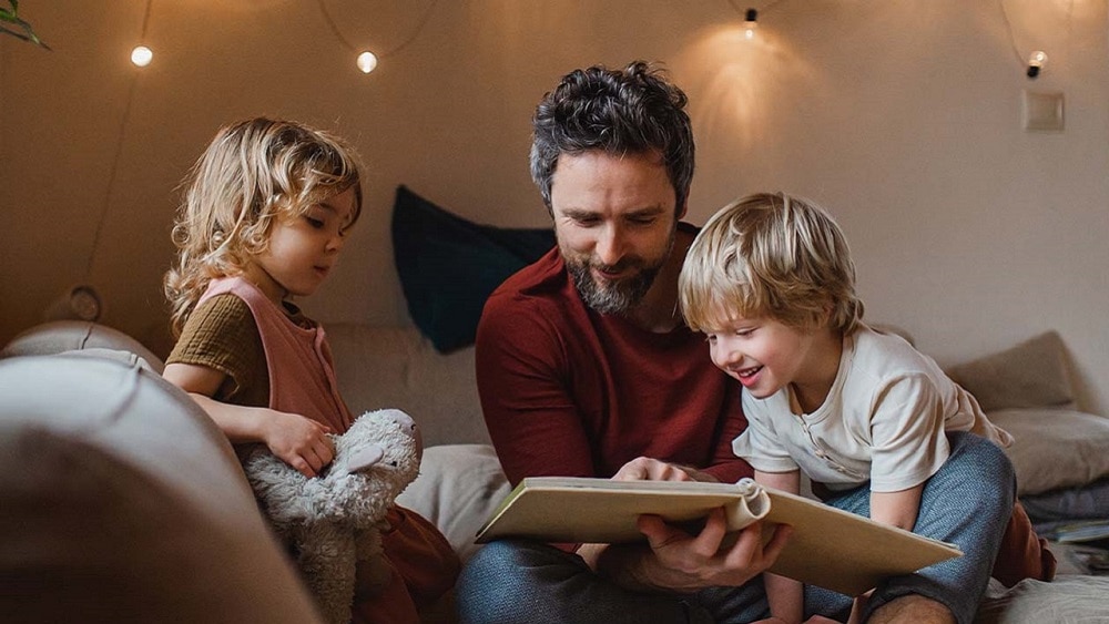 An adult reading to 2 children