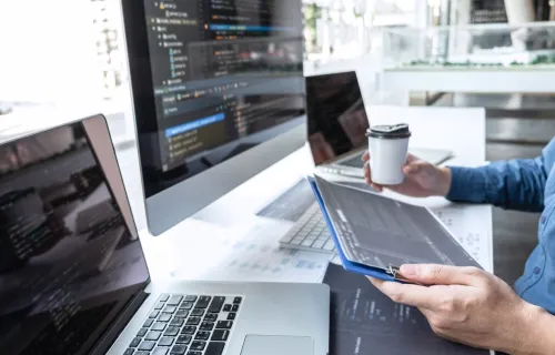 Consultant working with multiple computer screens