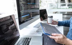 Consultant working with multiple computer screens